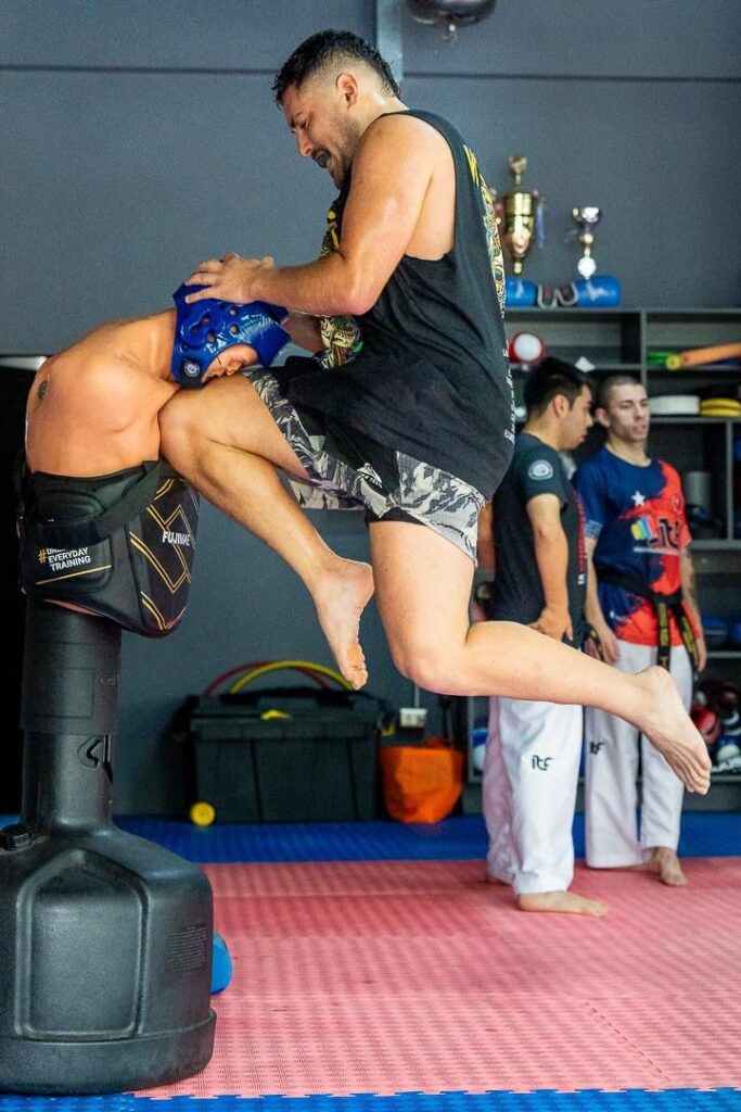 Alumno practicando rodillazo en clase de MMA
